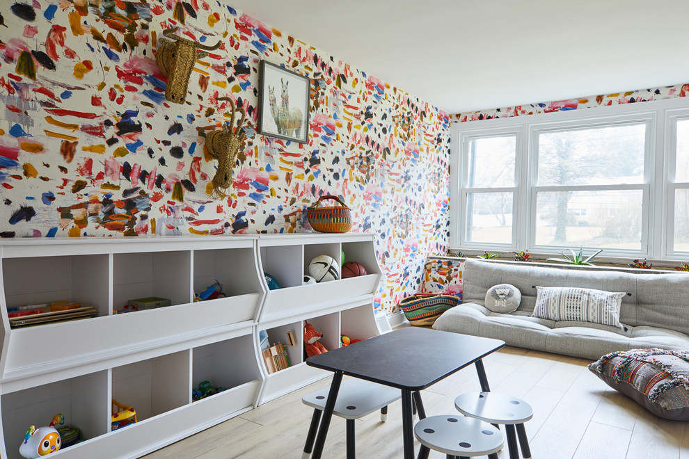 This is an example of a midcentury gender-neutral kids' playroom for kids 4-10 years old in Philadelphia with multi-coloured walls, light hardwood floors and beige floor.