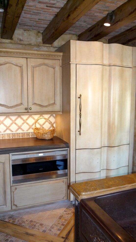 Eclectic kitchen photo in Phoenix with beige backsplash, stone tile backsplash, stainless steel appliances and an island