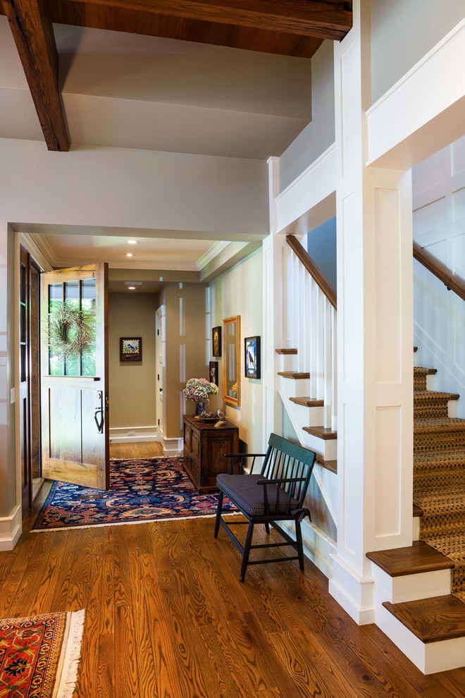 Traditional entryway in Other with a medium wood front door and grey walls.