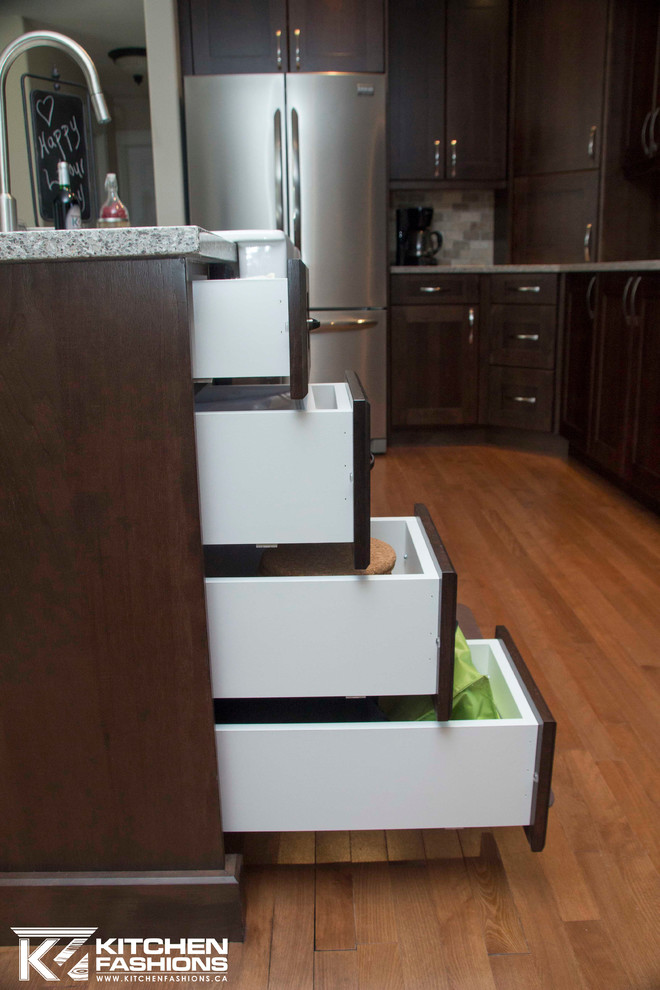 Large transitional u-shaped medium tone wood floor open concept kitchen photo with a farmhouse sink, shaker cabinets, dark wood cabinets, quartz countertops, brown backsplash, stone tile backsplash, stainless steel appliances and an island