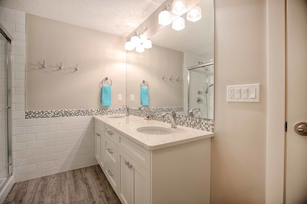 Alcove shower - mid-sized transitional 3/4 white tile and subway tile dark wood floor alcove shower idea in Calgary with white cabinets, white walls, an undermount sink and quartz countertops
