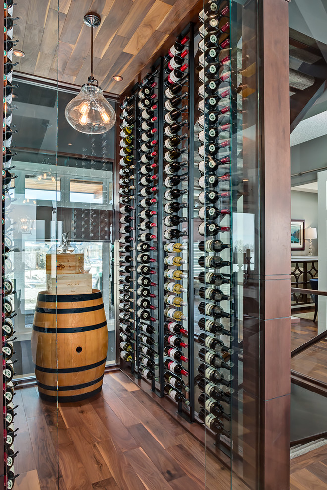 Contemporary wine cellar in Calgary with dark hardwood floors, display racks and brown floor.