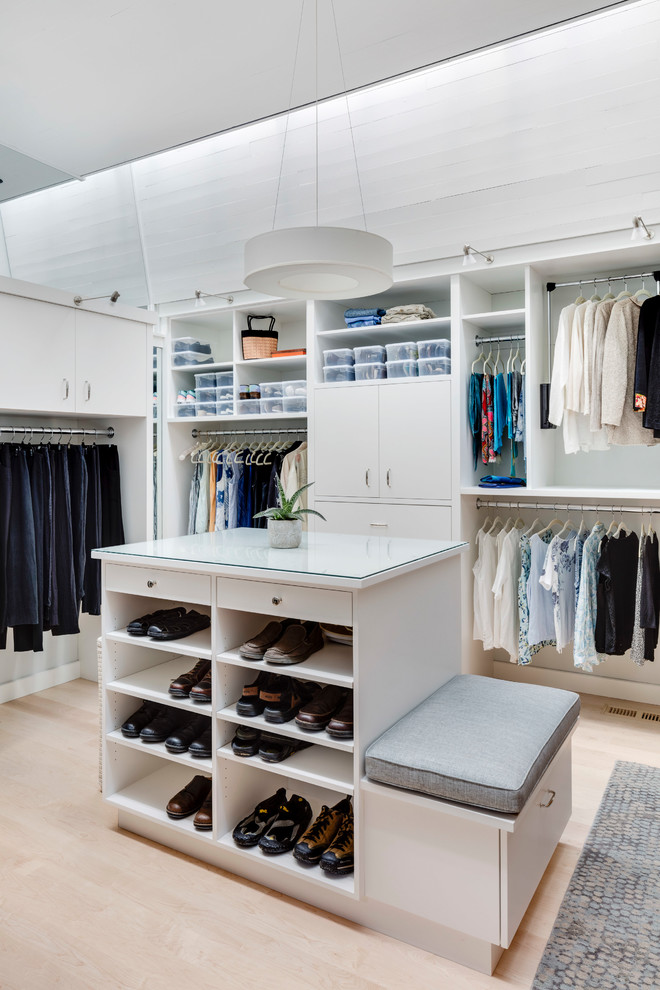 Design ideas for a large contemporary gender-neutral storage and wardrobe in Boston with white cabinets and dark hardwood floors.