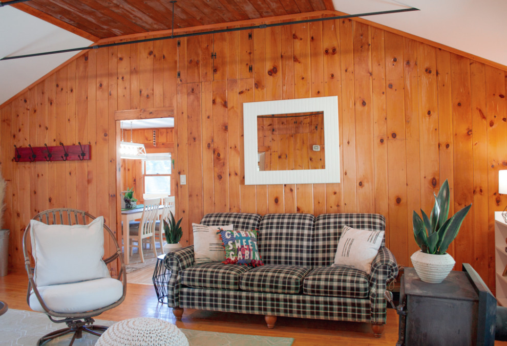 Mittelgroßes, Offenes Klassisches Wohnzimmer mit braunem Holzboden, Kaminofen, Kaminumrandung aus Backstein, verstecktem TV, gewölbter Decke und Wandpaneelen in Boston