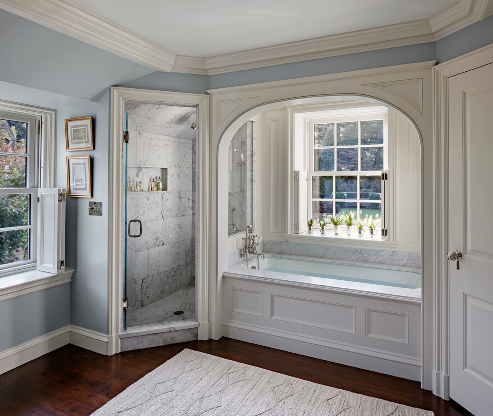 Inspiration for a large traditional master bathroom in New York with recessed-panel cabinets, white cabinets, an undermount tub, an alcove shower, white tile, stone tile, an undermount sink, marble benchtops, blue walls and dark hardwood floors.