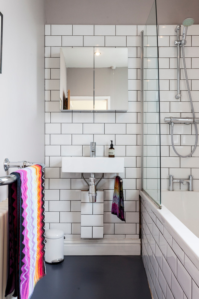 Inspiration for an eclectic bathroom in London with a wall-mount sink, a drop-in tub, a shower/bathtub combo and white tile.