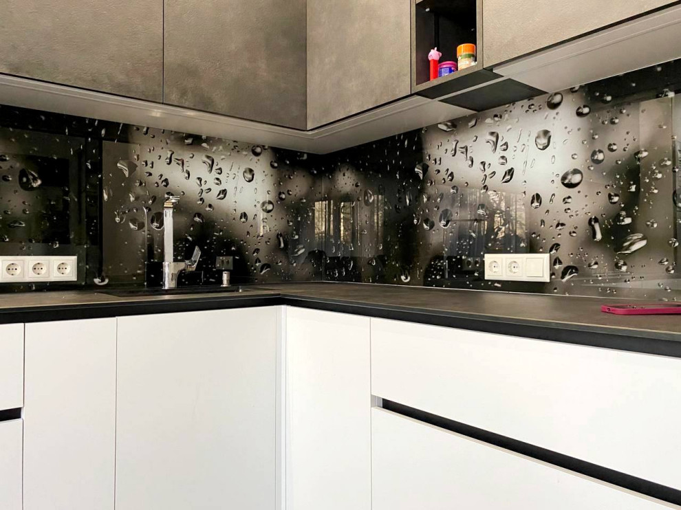 Immagine di una cucina contemporanea con paraspruzzi con lastra di vetro