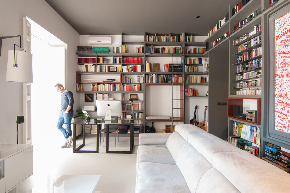 This is an example of a mid-sized contemporary home office in Madrid with white walls, a freestanding desk, light hardwood floors and white floor.