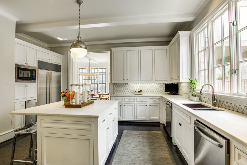 Design ideas for a large transitional u-shaped separate kitchen in Dallas with an undermount sink, shaker cabinets, white cabinets, marble benchtops, white splashback, stainless steel appliances, dark hardwood floors, with island and porcelain splashback.