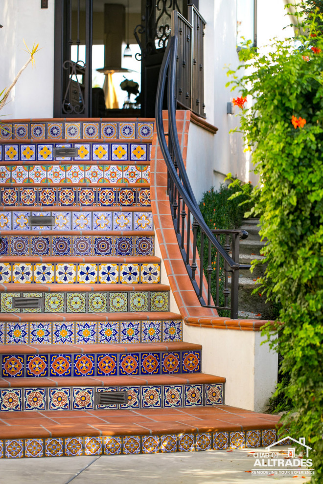 Mid-sized beach style front door in San Diego with white walls, terra-cotta floors, a single front door, a black front door and multi-coloured floor.