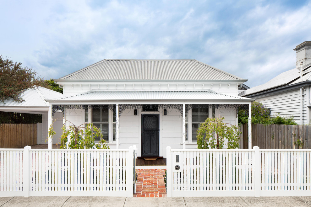 Mid-sized traditional one-storey white house exterior in Melbourne with wood siding, a hip roof and a metal roof.