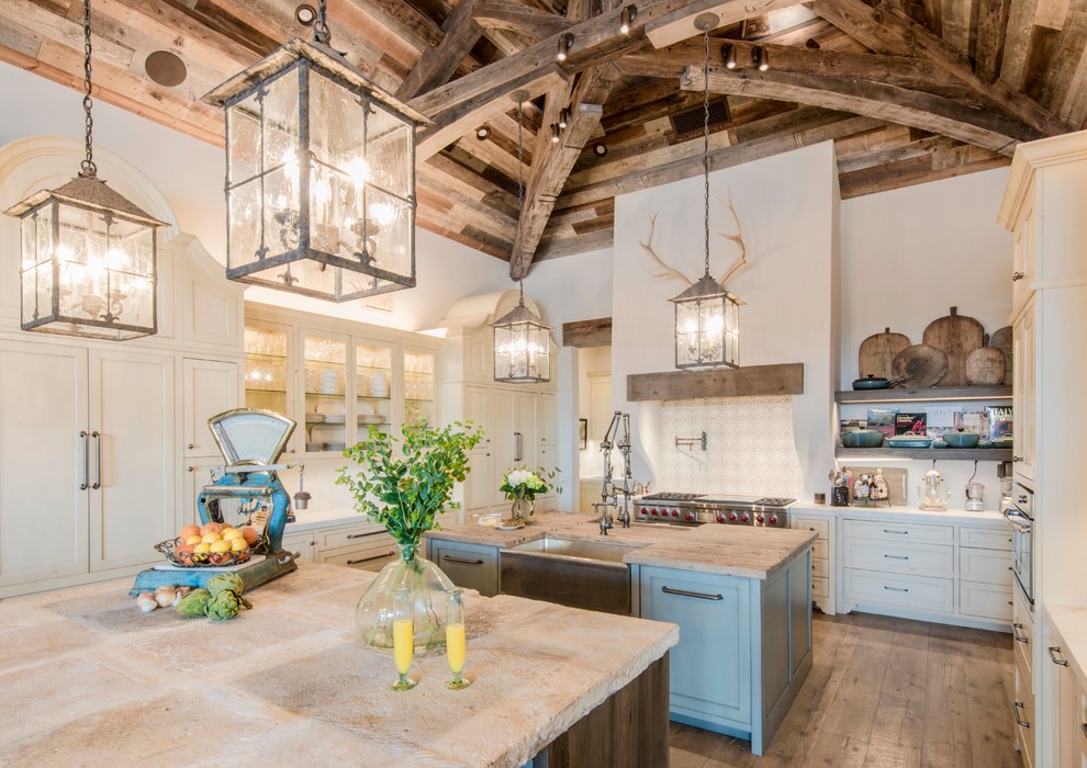 Inspiration for an expansive country u-shaped eat-in kitchen in Austin with a farmhouse sink, shaker cabinets, beige cabinets, beige splashback, panelled appliances, light hardwood floors, multiple islands, white benchtop, marble benchtops and terra-cotta splashback.