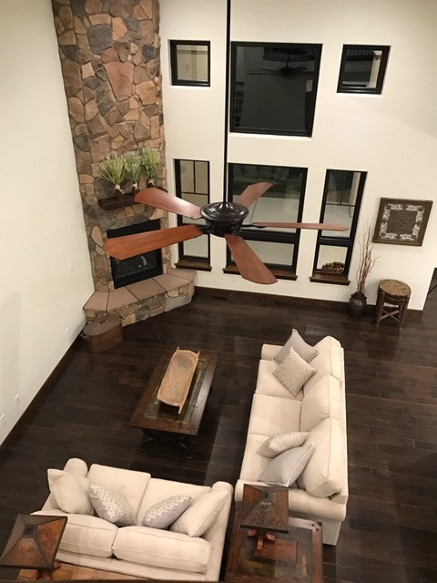 This is an example of a large contemporary open concept living room in Denver with white walls and dark hardwood floors.