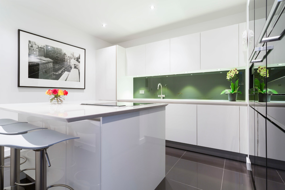 Inspiration for a mid-sized modern kitchen in London with white cabinets, green splashback and with island.