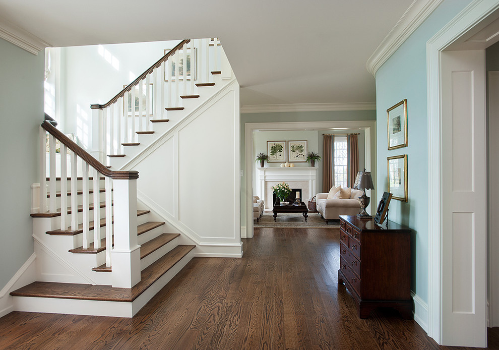 Photo of a traditional wood u-shaped staircase in Philadelphia with painted wood risers and wood railing.