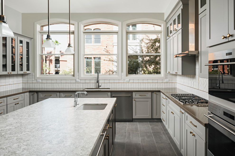 Inspiration for a large transitional galley ceramic tile and gray floor eat-in kitchen remodel in Phoenix with an undermount sink, shaker cabinets, gray cabinets, quartz countertops, white backsplash, ceramic backsplash, stainless steel appliances, an island and gray countertops