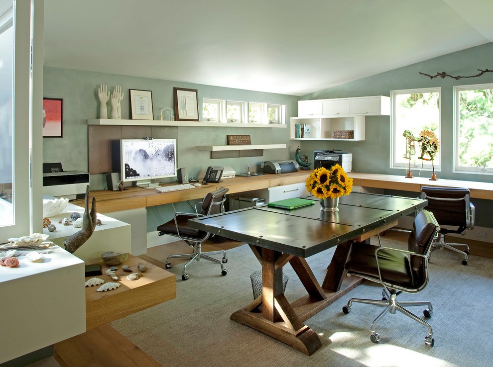 Home office - large transitional built-in desk medium tone wood floor home office idea in New York with blue walls