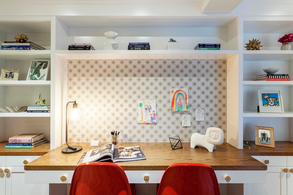 Mid-sized transitional craft room in New York with white walls, medium hardwood floors and a built-in desk.