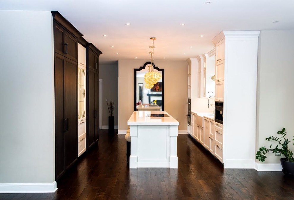 Example of a mid-sized transitional single-wall dark wood floor enclosed kitchen design with a farmhouse sink, shaker cabinets, white cabinets, white backsplash, stainless steel appliances and an island