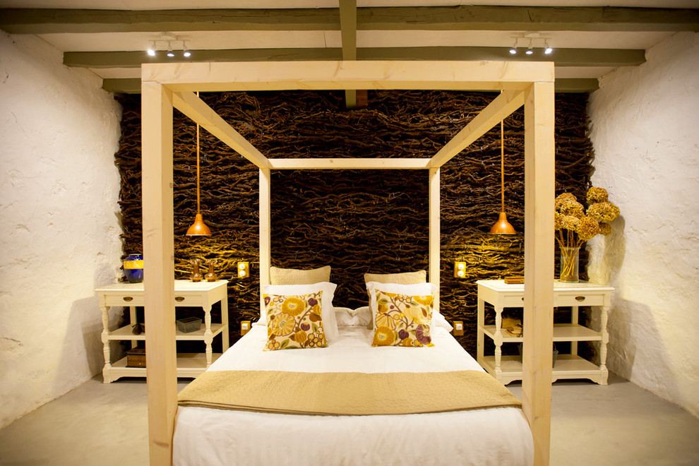 Modelo de dormitorio principal ecléctico de tamaño medio sin chimenea con paredes blancas y suelo de cemento