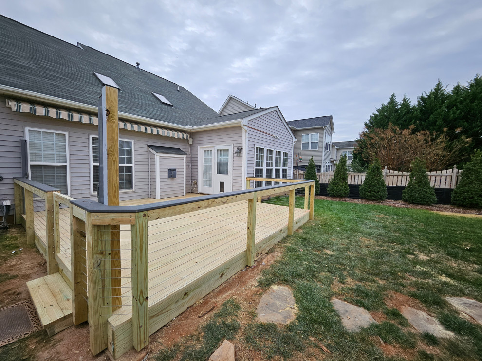 Ground level cable railing deck photo in Charlotte