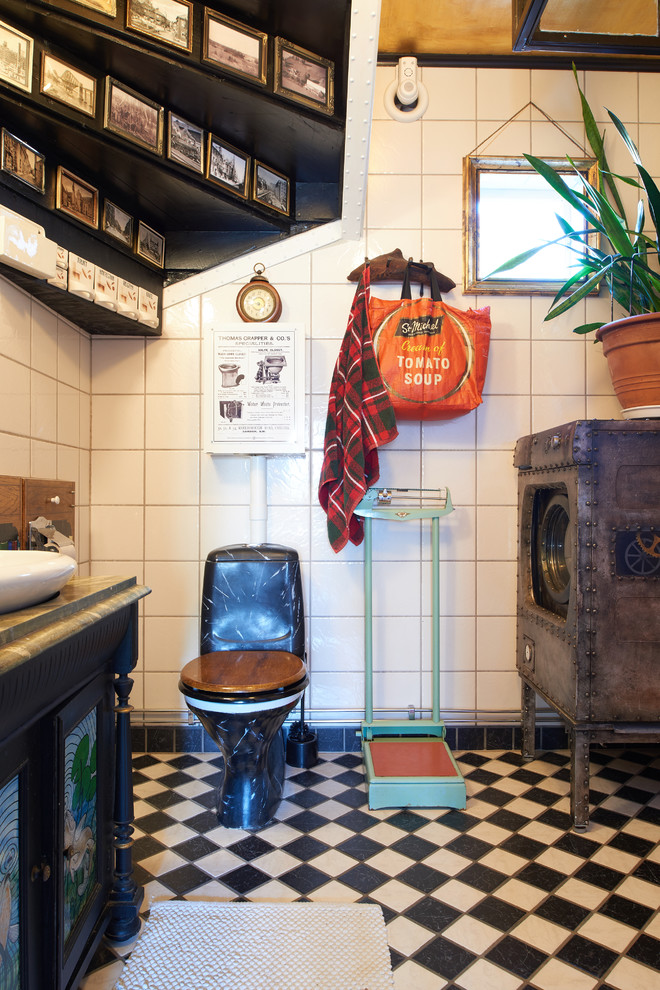 Design ideas for an eclectic powder room in Gothenburg with shaker cabinets, a two-piece toilet, white tile and black floor.