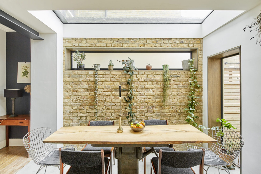 This is an example of a medium sized contemporary grey and white single-wall kitchen/diner in London with an integrated sink, flat-panel cabinets, concrete worktops, stainless steel appliances, concrete flooring, no island, grey floors, grey worktops and feature lighting.