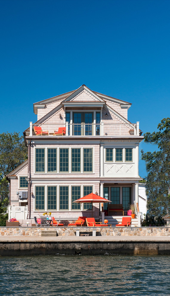 Design ideas for a mid-sized beach style three-storey pink exterior in New York with wood siding.