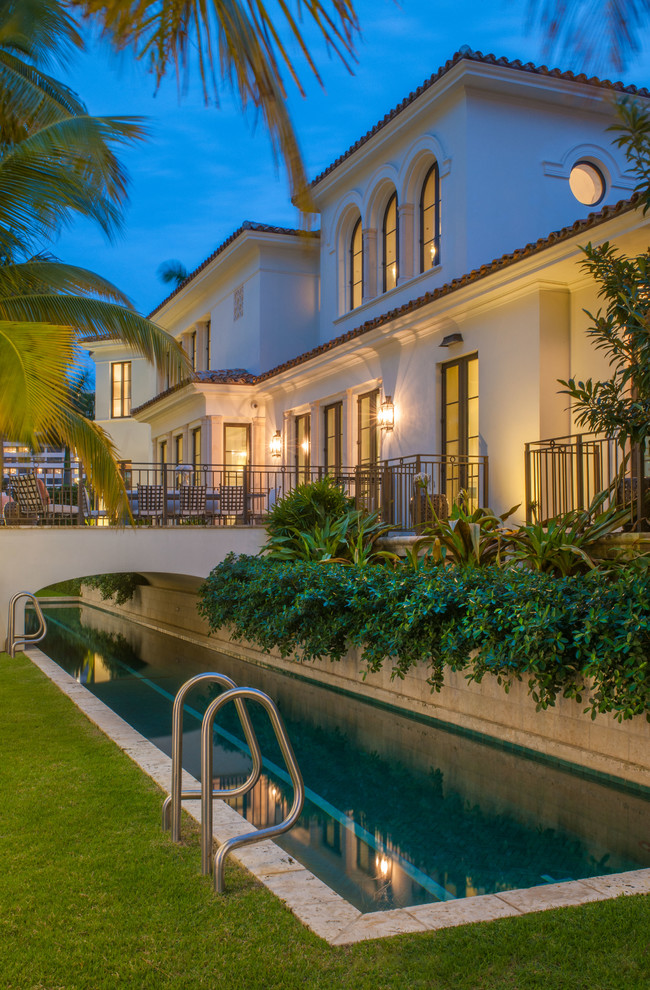 Inspiration for a huge mediterranean stone and rectangular lap pool house remodel in Miami