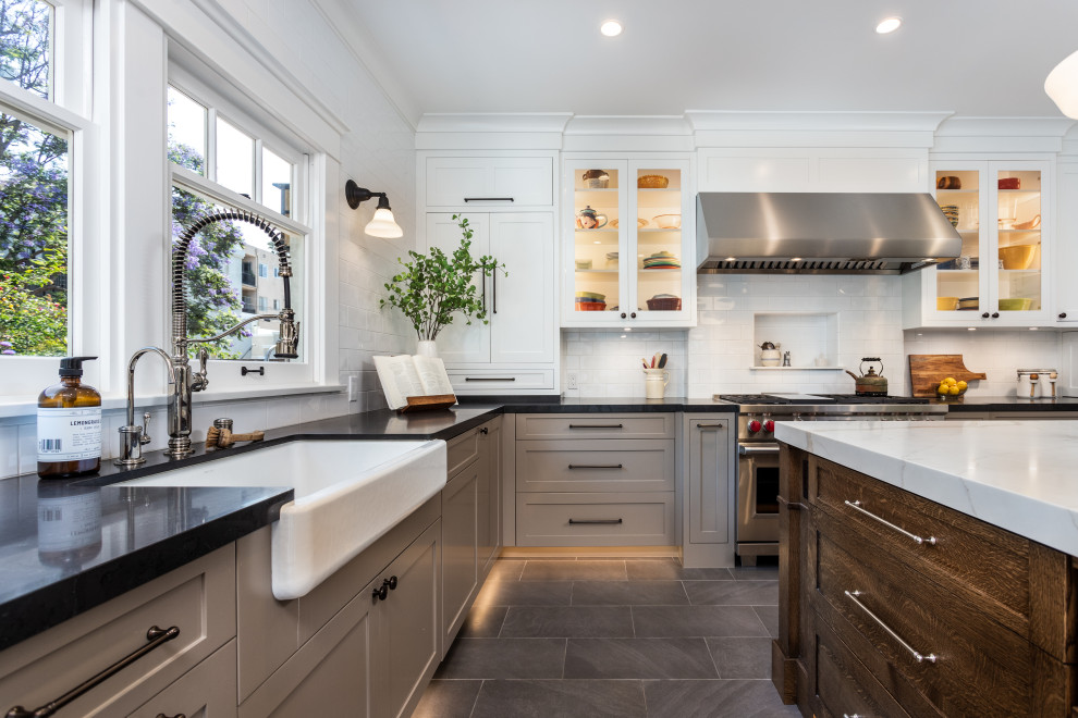 Mid-sized arts and crafts gray floor enclosed kitchen photo in Los Angeles with a farmhouse sink, white backsplash, stainless steel appliances, an island and white countertops