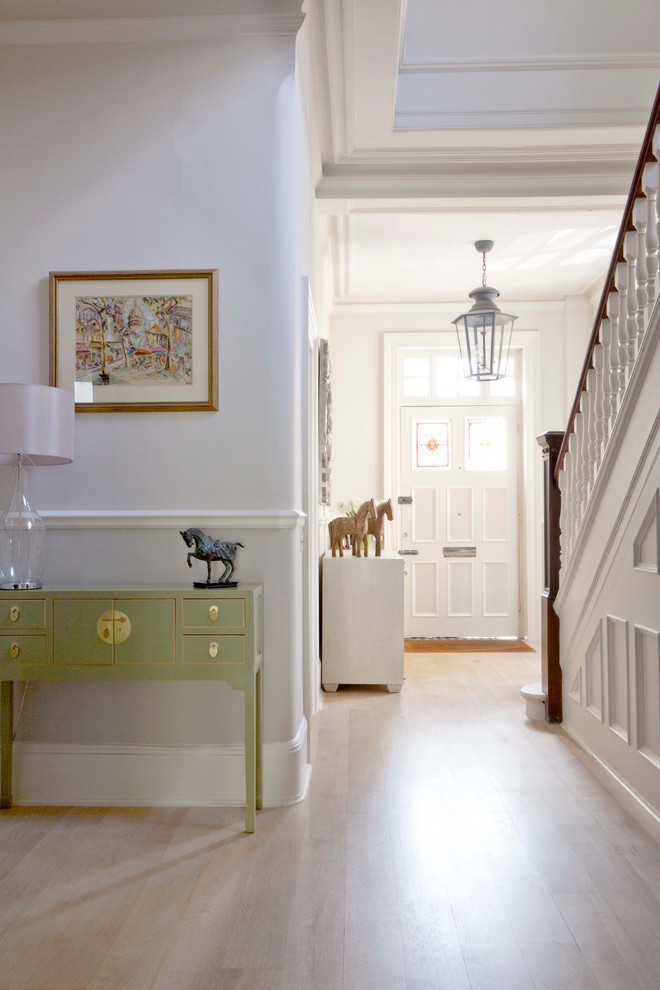 This is an example of a traditional hallway in London with light hardwood floors.