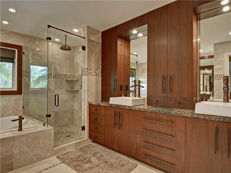 Inspiration for a large tropical master bathroom in Miami with a vessel sink, flat-panel cabinets, dark wood cabinets, granite benchtops, a drop-in tub, a corner shower, a one-piece toilet, beige tile, stone tile, beige walls and marble floors.
