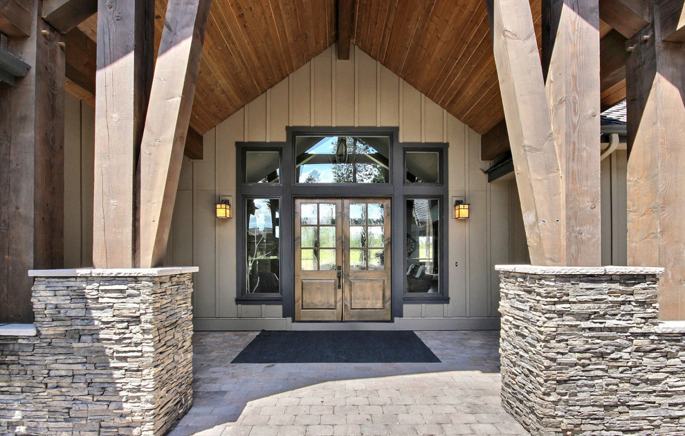 Expansive arts and crafts front door in Portland with beige walls, concrete floors, a double front door, a dark wood front door, beige floor, vaulted and panelled walls.