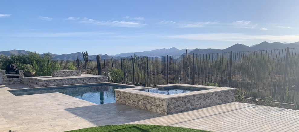 Example of a large transitional backyard stone and custom-shaped pool design in Phoenix with a bbq area