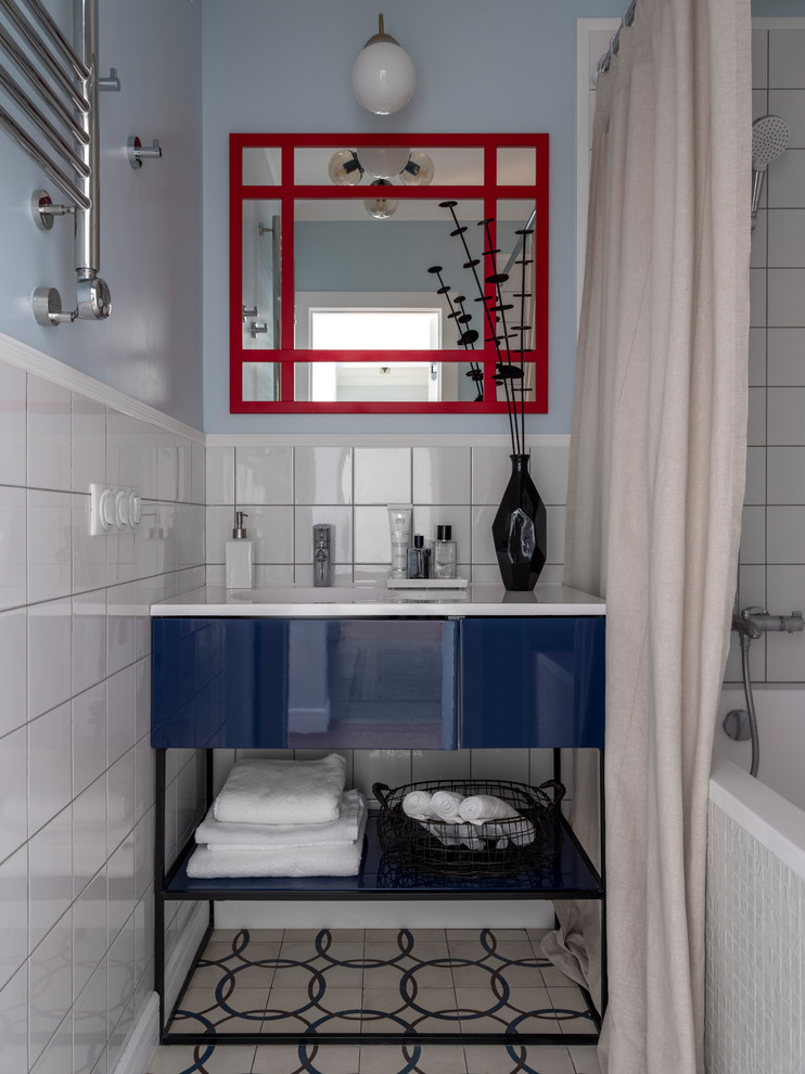Photo of a small contemporary master bathroom in Moscow with flat-panel cabinets, blue cabinets, an alcove tub, a shower/bathtub combo, white tile, blue walls, an integrated sink, beige floor, a shower curtain and white benchtops.