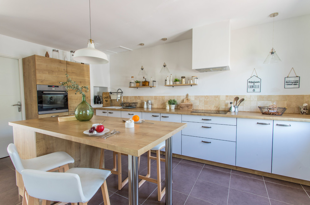 This is an example of a large country l-shaped eat-in kitchen in Lyon with a single-bowl sink, flat-panel cabinets, white cabinets, laminate benchtops, beige splashback, stone tile splashback, ceramic floors, with island, brown floor and stainless steel appliances.