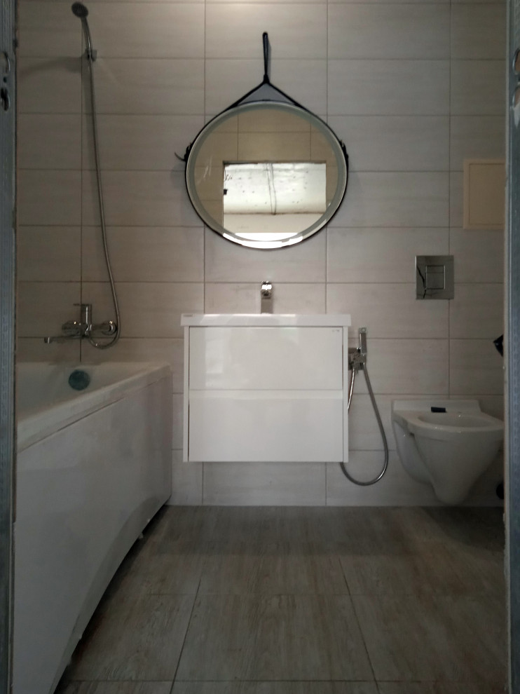 На фото: ванная комната среднего размера с плоскими фасадами, белыми фасадами, полновстраиваемой ванной, душем в нише, инсталляцией, бежевой плиткой, керамической плиткой, бежевыми стенами, полом из керамической плитки, душевой кабиной, душем с раздвижными дверями, тумбой под две раковины и подвесной тумбой