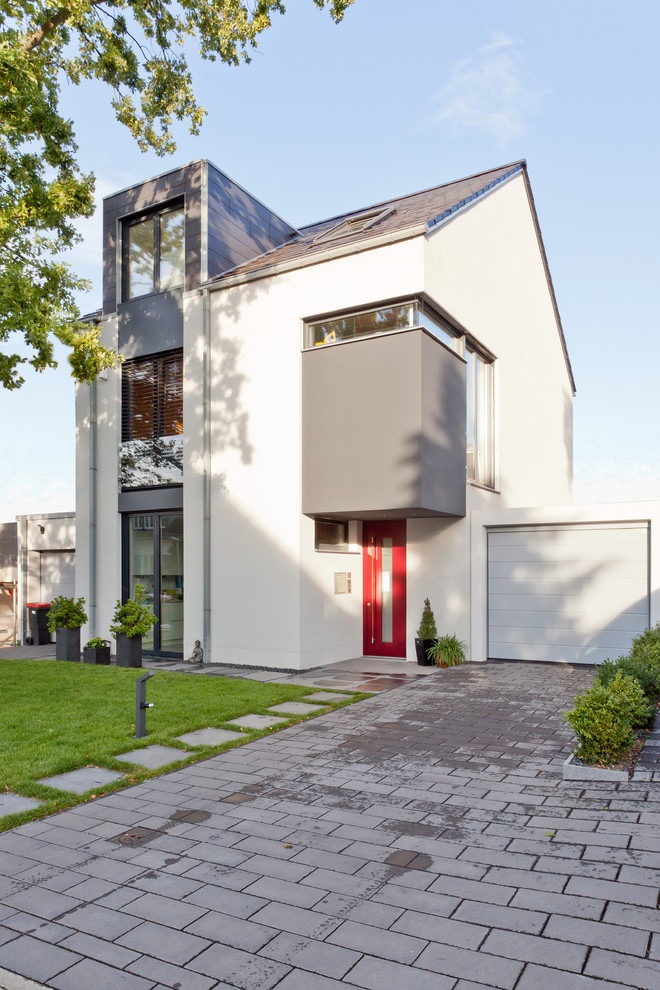 Mid-sized contemporary three-storey white exterior in Cologne with a gable roof.