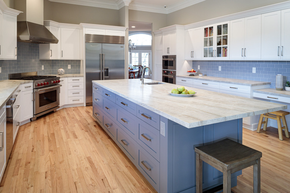 Photo of an expansive classic kitchen/diner in San Francisco with shaker cabinets, blue cabinets, engineered stone countertops, blue splashback, metro tiled splashback, stainless steel appliances, an island and white worktops.