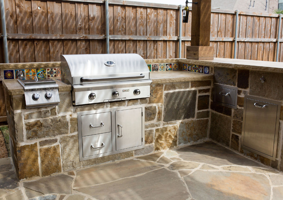 Inspiration for a mid-sized transitional backyard patio in Dallas with an outdoor kitchen, natural stone pavers and a pergola.
