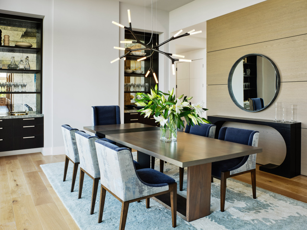 Large modern kitchen/dining combo in San Francisco with white walls, light hardwood floors and wood walls.