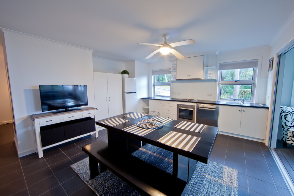 Photo of a transitional open plan kitchen in Gold Coast - Tweed with a double-bowl sink, white cabinets, granite benchtops, stainless steel appliances and with island.