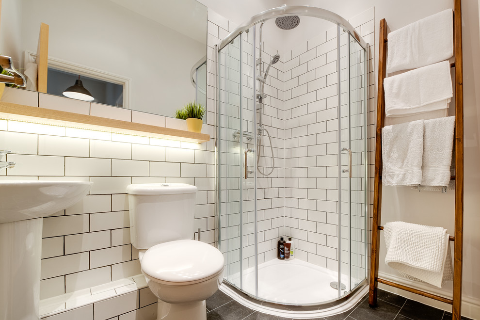 Small contemporary 3/4 bathroom in Other with a pedestal sink, wood benchtops, a corner shower, a two-piece toilet, white tile, subway tile, grey walls and vinyl floors.