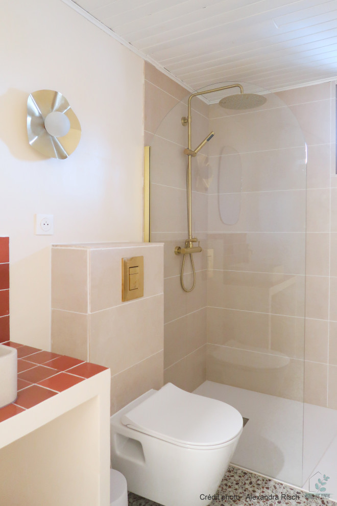 Kleines Mediterranes Badezimmer mit bodengleicher Dusche, Wandtoilette, beigen Fliesen, Keramikfliesen, beiger Wandfarbe, Terrazzo-Boden, Einbauwaschbecken, gefliestem Waschtisch, buntem Boden, oranger Waschtischplatte und Einzelwaschbecken in Straßburg