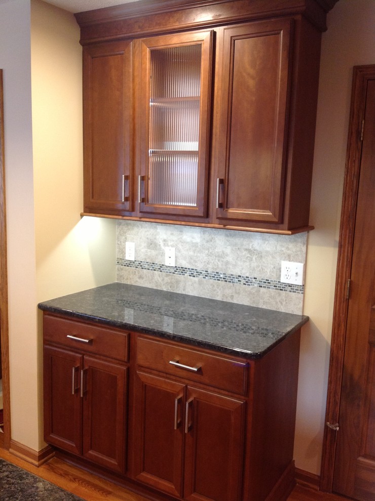 Eat-in kitchen - mid-sized transitional l-shaped medium tone wood floor eat-in kitchen idea with an undermount sink, recessed-panel cabinets, medium tone wood cabinets, granite countertops, gray backsplash, stone tile backsplash, stainless steel appliances, gray walls and an island