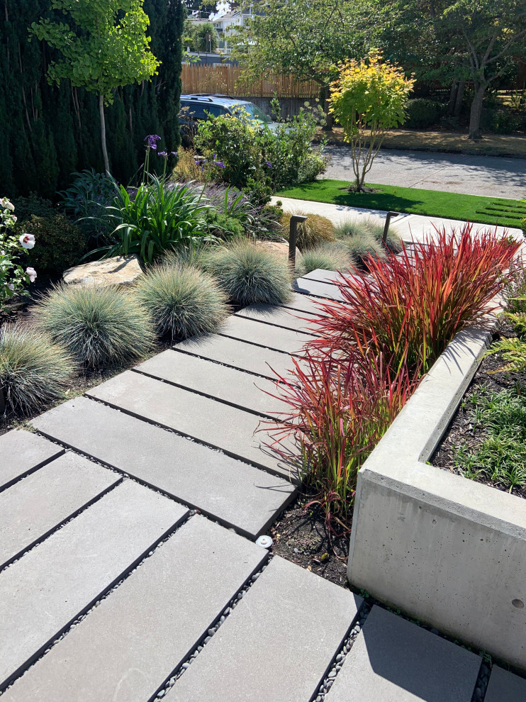 This is an example of a mid-sized contemporary front yard partial sun garden in Seattle with concrete pavers.