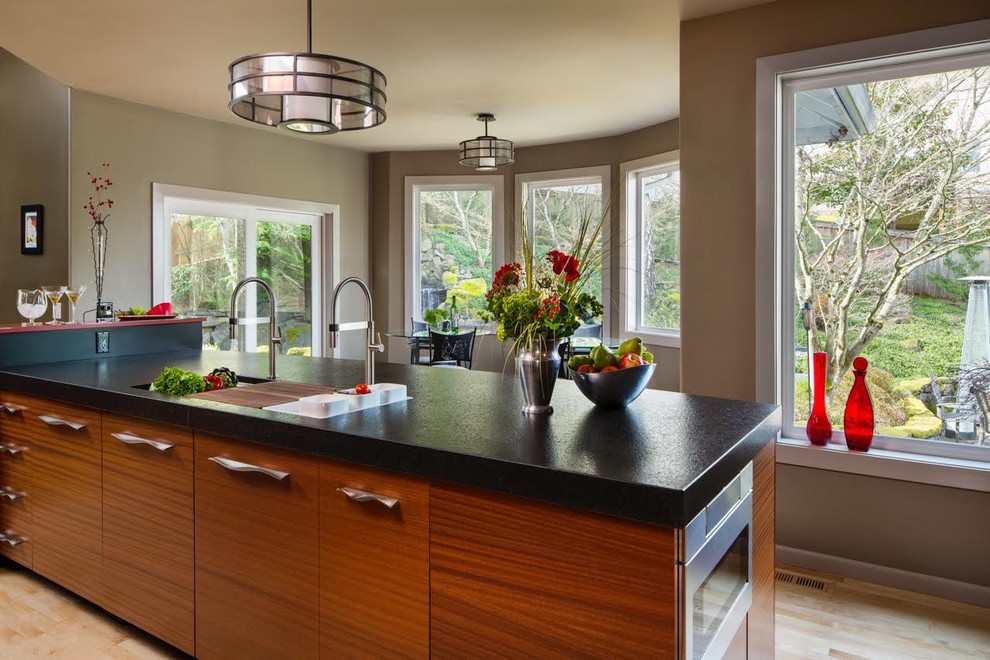 Large contemporary u-shaped eat-in kitchen in Portland with flat-panel cabinets, medium wood cabinets, solid surface benchtops, red splashback, glass sheet splashback, panelled appliances, light hardwood floors, with island, a double-bowl sink and beige floor.