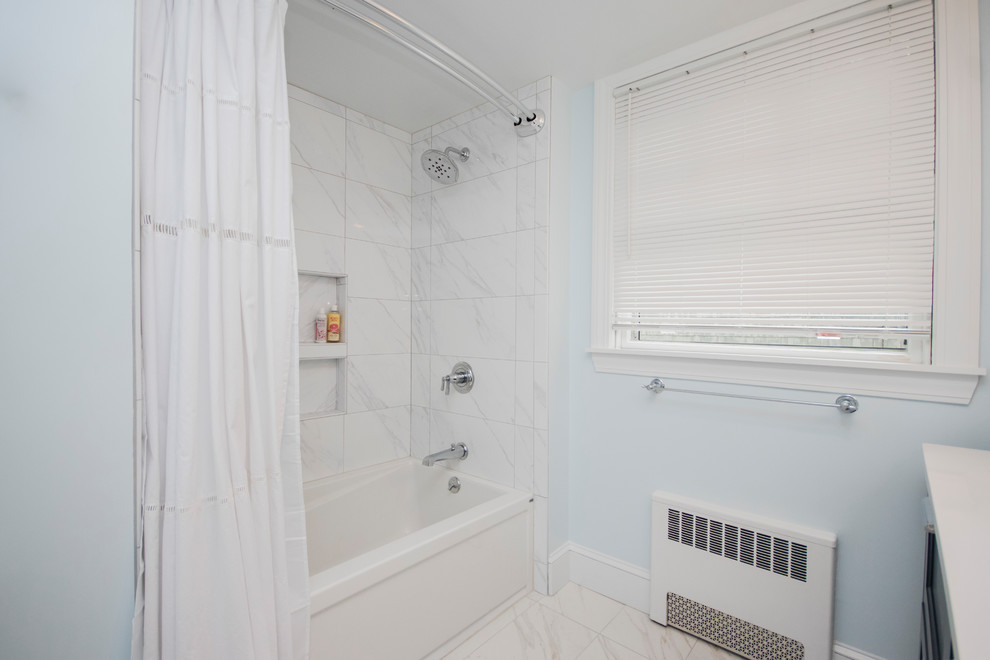 Photo of a mid-sized modern master bathroom in Providence with beaded inset cabinets, blue cabinets, a drop-in tub, an open shower, a one-piece toilet, white tile, ceramic tile, blue walls, ceramic floors, an undermount sink, tile benchtops, white floor and a shower curtain.