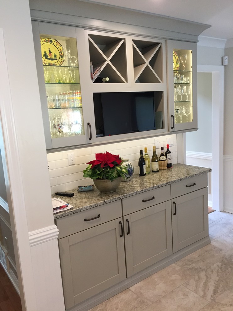 Photo of a transitional u-shaped eat-in kitchen in Other with an undermount sink, shaker cabinets, white cabinets, granite benchtops, white splashback, ceramic splashback, stainless steel appliances, porcelain floors and no island.