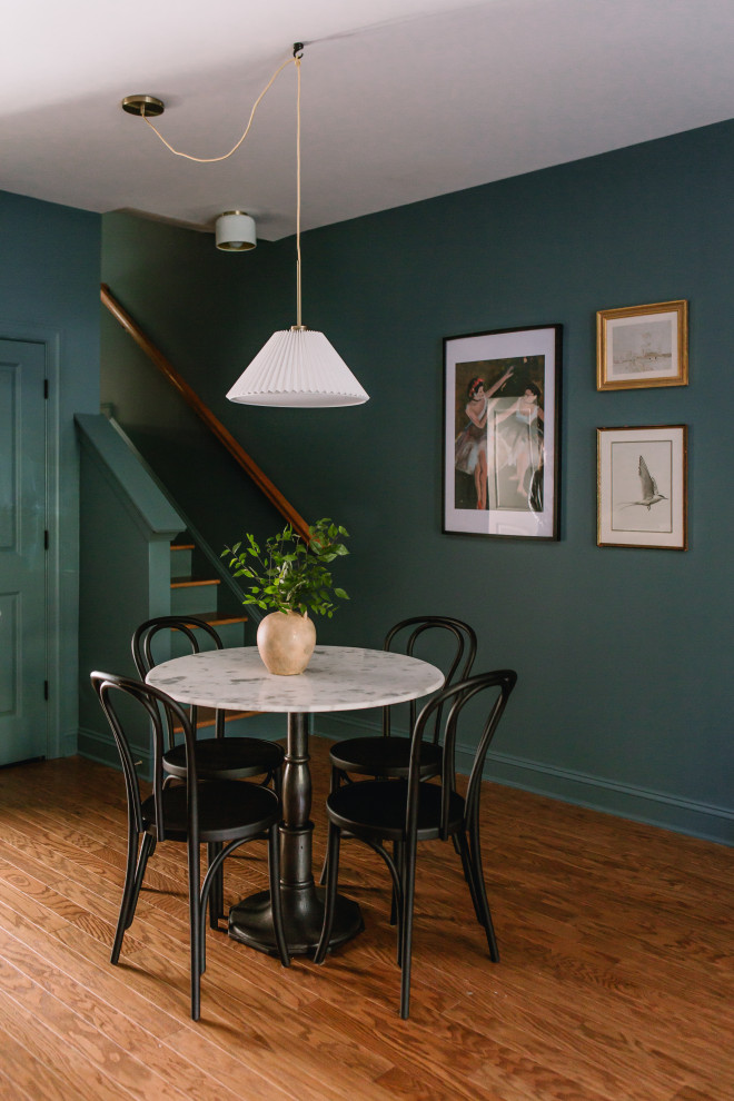 Cette photo montre une salle à manger éclectique de taille moyenne avec un mur bleu, un sol en bois brun, aucune cheminée et un sol jaune.